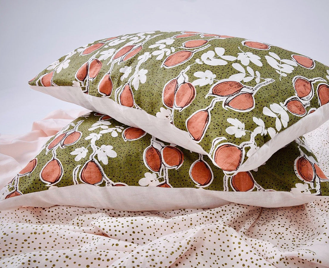 Seed pods in rust_olive on shell pink linen