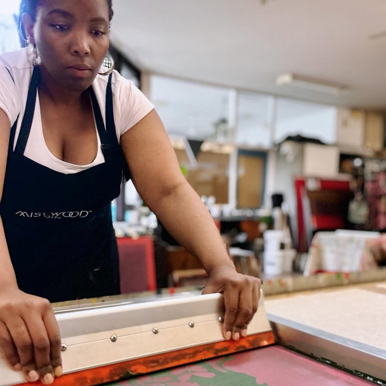 Person working screen printing press in a workshop setting